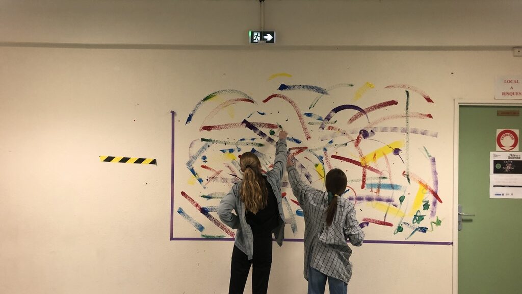 Deux élèves décorent un mur du collège Alfred Manessier de Flixecourt en réalisant une œuvre d'art (abstrait) comprenant de multiples couleurs. L'image a vocation à illustrer la CHAAP. 